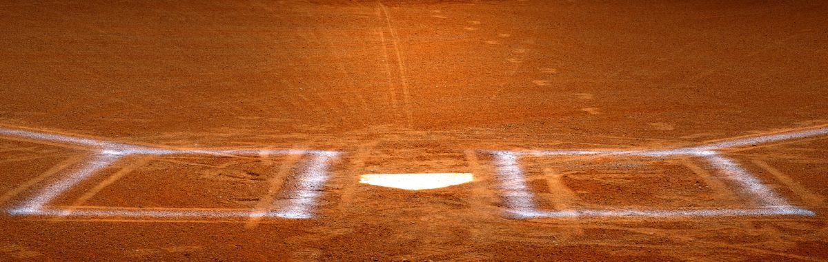 Baseball homeplate with batter box chalk lines in brown clay dirt